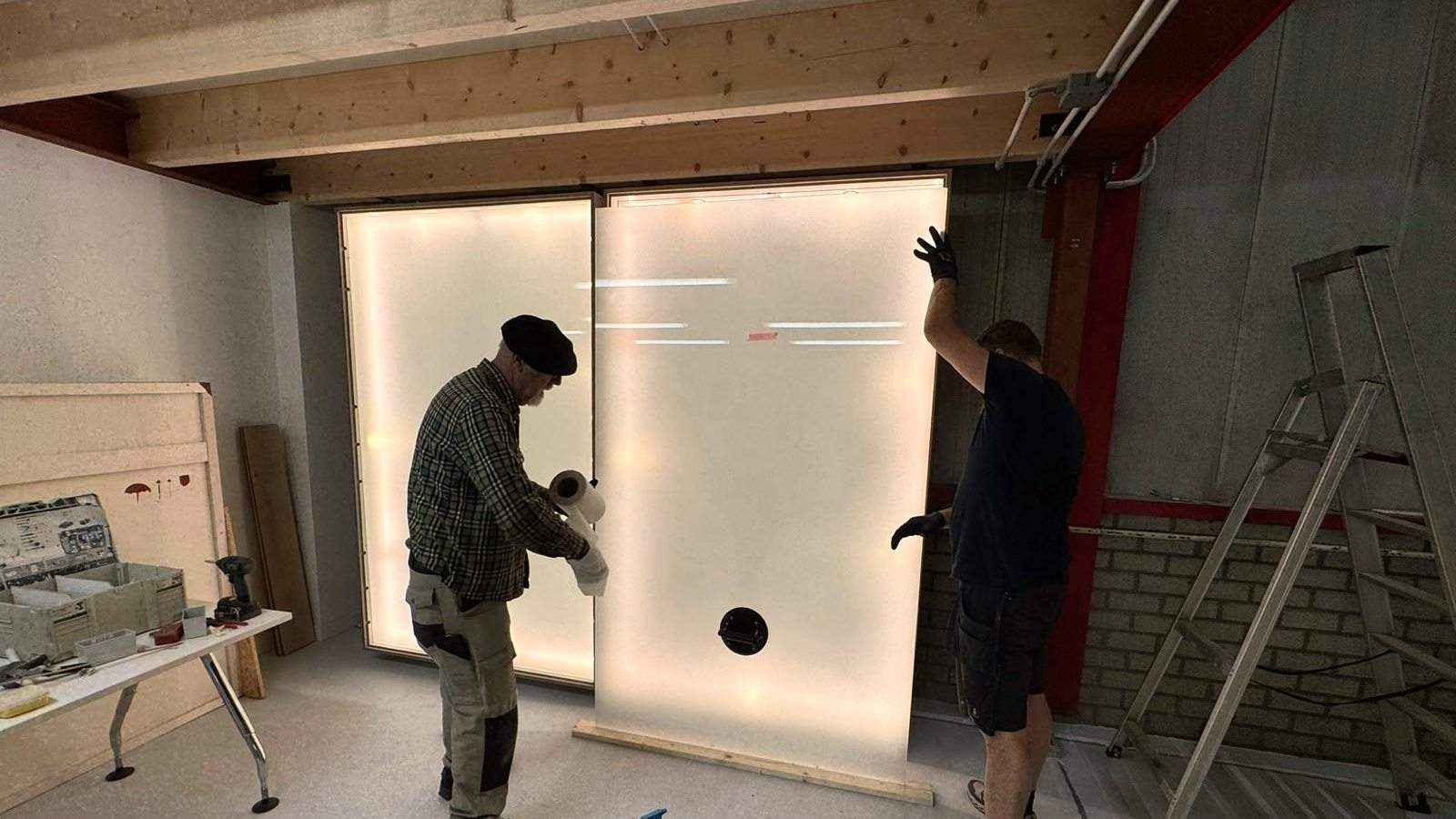 Een grote verlichte glaswand plaatsen
