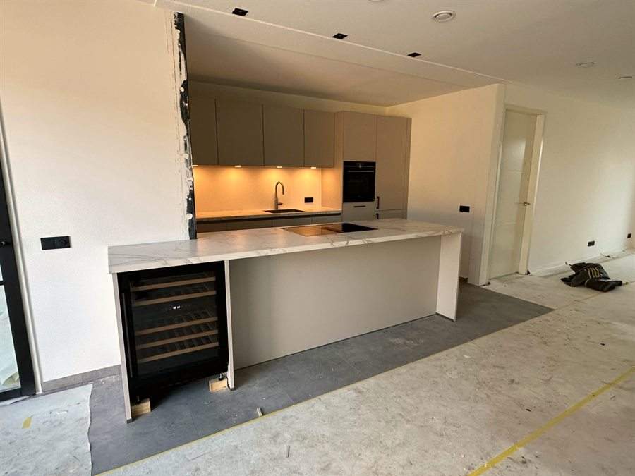 Lange kastenwand met wijnkoeler, huis nog in aanbouw