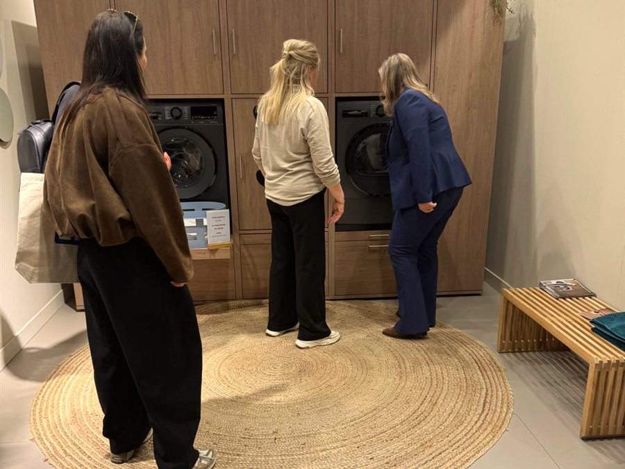 Klanten bekijken een apparatuurwand in de showroom